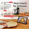 A kitchen scene with a stand mixer, a tablet displaying a baking tutorial, and a person preparing dough in a tart pan. Produktbild-Vorschau
