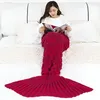 Rote gestrickte Meerjungfrau-Schwanzdecke, getragen von einer Frau, die auf einem weißen Bett sitzt und eine Zeitschrift liest Anteprima dell’immagine prodotto