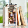A miniature book nook designed to look like a shop, placed between two books. Podgląd zdjęcia produktu