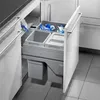 A pull-out kitchen trash bin system with multiple compartments, filled with plastic bags and recyclables. Produktbild-Vorschau