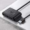 A black USB hub with multiple ports is placed on a light-colored surface, likely a desk or laptop. Náhľad obrázku produktu