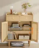 A light wood cabinet with rattan doors, displaying various items on its shelves. Produktbild-Vorschau