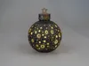 A decorative Christmas ornament with cutouts of stars and suns, illuminated from within, against a plain gray background. Produktbild-Vorschau