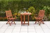 A wooden garden furniture set with two chairs and a table on a paved patio, with a green hedge and flowers in the background. Produktbild-Vorschau