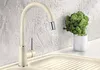 A cream-colored kitchen faucet with a silver tip is shown in a sink, next to a small potted plant. Náhľad obrázku produktu