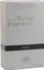 Schlichte Umverpackung von Voyage d’Hermès Parfum mit schwarzem Streifen und dezentem Schriftzug auf hellem Hintergrund. Voir les images du produit
