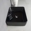 A black rectangular sink is shown from a slightly elevated angle, placed on a marble-like countertop. Podgląd zdjęcia produktu