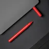A red pen and a red cap are placed on a black textured surface next to a gray object. Produktbild-Vorschau