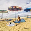 People relaxing on a beach under umbrellas with an inflatable tray of drinks. Náhled obrázku produktu