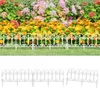 A white decorative garden border fence in front of a flower bed. Produktbild-Vorschau