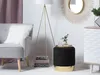 A stylish living room scene featuring a gray armchair, a gold tripod floor lamp, and a black velvet pouf with a gold base. Náhled obrázku produktu