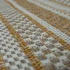A close-up view of a woven rug with a striped pattern. Produktbild-Vorschau