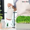 A person watering microgreens with a watering can. Produktbild-Vorschau