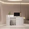A white reception desk with a computer and a plant on it, set against a light beige wall. Produktbild-Vorschau
