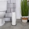 A toilet paper holder with four rolls of toilet paper next to a toilet and a potted plant. Voir les images du produit