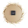 The back of a round wall clock with a straw-like border and a clock mechanism is shown against a white background. Podgląd zdjęcia produktu