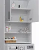 A white cabinet designed to fit over a washing machine, with shelves holding various items. Produktbild-Vorschau