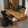 A vanity table with drawers open, showing makeup and accessories, with a stool and a mirror. Voir les images du produit