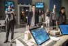A group of people stand in a high-tech room with monitors and a statue of The Flash. Podgląd zdjęcia produktu