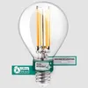 A close-up studio shot of a clear glass LED light bulb with visible filament elements, set against a light gray background. Promotional text and badges are overlaid on the image. Produktbild-Vorschau