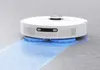 A white robotic vacuum cleaner with rotating mop pads is cleaning a floor, leaving a wet blue trail. Voir les images du produit