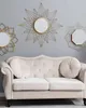 A cream-colored sofa with decorative pillows is placed against a light gray wall, adorned with three starburst-style mirrors. Náhled obrázku produktu