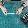 Hands assembling a tool set on a cutting mat. Anteprima dell’immagine prodotto