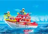 A red and white fire rescue boat with two figures on deck, sailing on blue water with industrial cranes in the background. Produktbild-Vorschau
