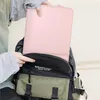 A person is placing a pink laptop sleeve into a backpack. Anteprima dell’immagine prodotto