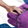 A hand is shown touching a folded purple blanket. Produktbild-Vorschau