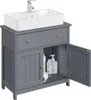 A dark gray bathroom vanity with a white sink and faucet, shown with its doors open to reveal storage space containing toiletries and a roll of toilet paper. Produktbild-Vorschau