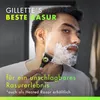 A man is shaving his face with a Gillette razor, with shaving foam on his face. Produktbild-Vorschau