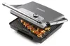 A Domo brand contact grill with skewers of food cooking on it. Podgląd zdjęcia produktu