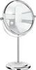 A silver-colored double-sided vanity mirror with a stand, reflecting a bathroom interior. Produktbild-Vorschau