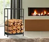 A black metal firewood rack filled with logs is placed next to a modern fireplace with a fire burning. Podgląd zdjęcia produktu