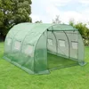 A green greenhouse tunnel set up on a grassy lawn with trees and a blue sky in the background. Podgląd zdjęcia produktu
