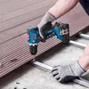 A person wearing gloves is using a Bosch cordless drill to attach a composite decking board to a metal frame. Náhled obrázku produktu