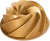 A gold-colored bundt cake pan with a swirling design. Podgląd zdjęcia produktu