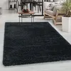 A dark gray shaggy rug is shown in a living room setting. Produktbild-Vorschau