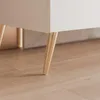 Close-up of the legs of a white TV lowboard on a wooden floor. Voir les images du produit
