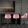 Three pink velvet bar stools are arranged in a modern kitchen setting. Voir les images du produit