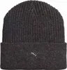 A close-up studio shot of a dark gray knitted beanie with a silver Puma logo. Náhled obrázku produktu