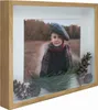 A shadow box frame with a photo of a child and decorative pine cones and branches. Náhled obrázku produktu