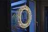 A lit wreath hangs on a glass door, reflecting the interior. Produktbild-Vorschau