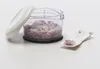 A manual chopper filled with chopped red onions, with its lid open and resting to the side. A small white spoon with some chopped onions is placed next to it. Produktbild-Vorschau