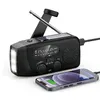 A black emergency radio with a solar panel, LED flashlight, and a smartphone connected to it for charging. Podgląd zdjęcia produktu