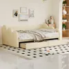 A beige upholstered daybed with cloud-shaped headrests and sides, featuring two pull-out drawers underneath. The bed is made with artificial leather fabric and includes a throw blanket and pillows.
