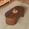 A wooden coffee table on a rug in a living room setting. Produktbild-Vorschau