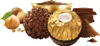 A collection of Ferrero Rocher chocolates, hazelnuts, and chocolate pieces arranged on a white background. Produktbild-Vorschau