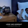 A fan is placed on a nightstand next to a sleeping person. Náhľad obrázku produktu